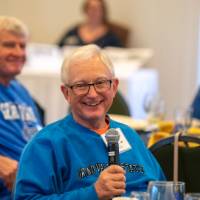 An alumnus speaking to the audience.